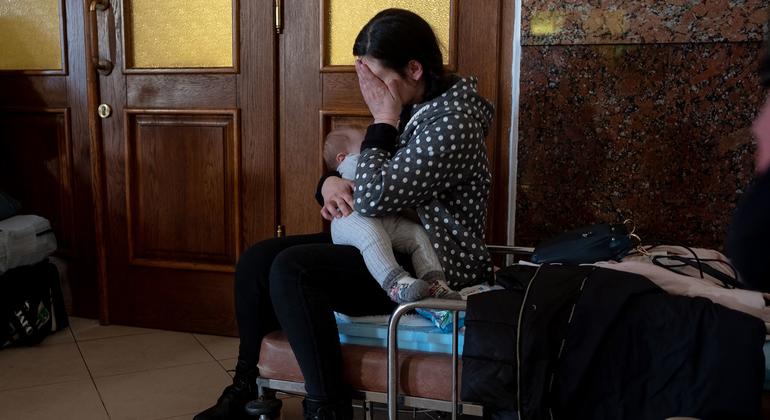 Ukrainians at Lviv train station prepare to leave their country.