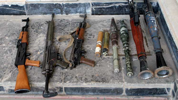 Various small arms and munitions laid out in the street