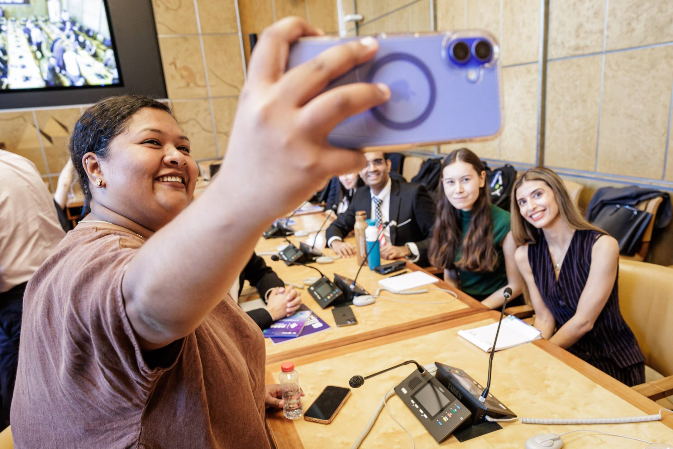 An attendee takes a selfie with UNIDIR Space Security Research Fellows during OS26.